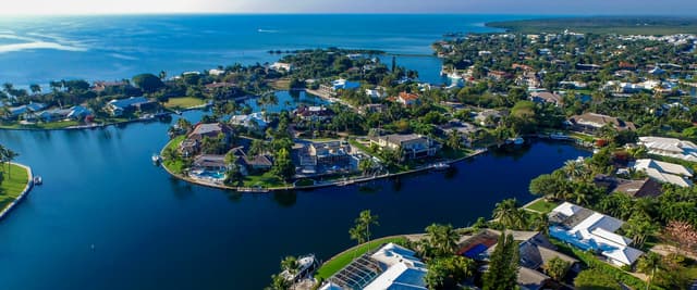 Aerial view of Key Largo, Florida, with winding waterways, lush tropical vegetation, and the Gulf of Mexico in the background